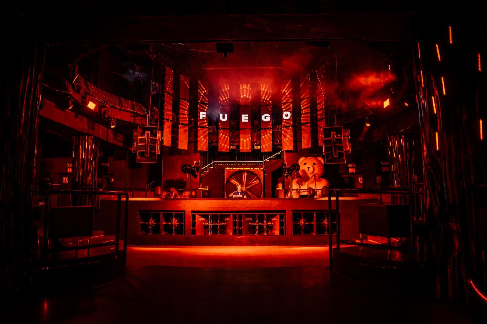 Escenario de Fuego en Eden Ibiza iluminado en rojo, con el rótulo FUEGO sobre la cabina